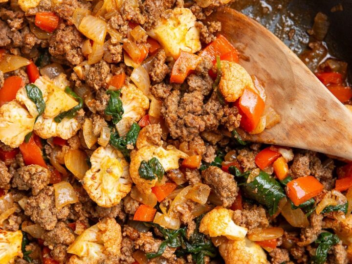 A skillet with meat and vegetables in it.