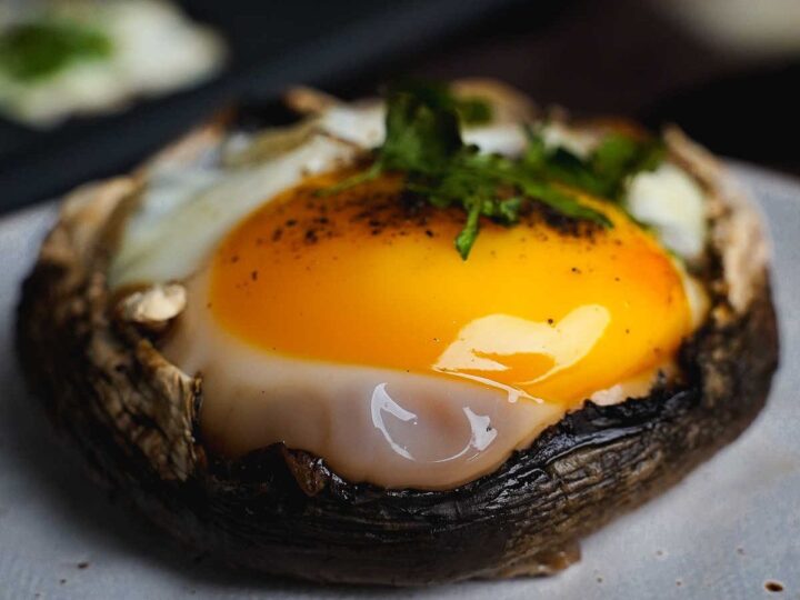A mushroom topped with an egg and herbs.