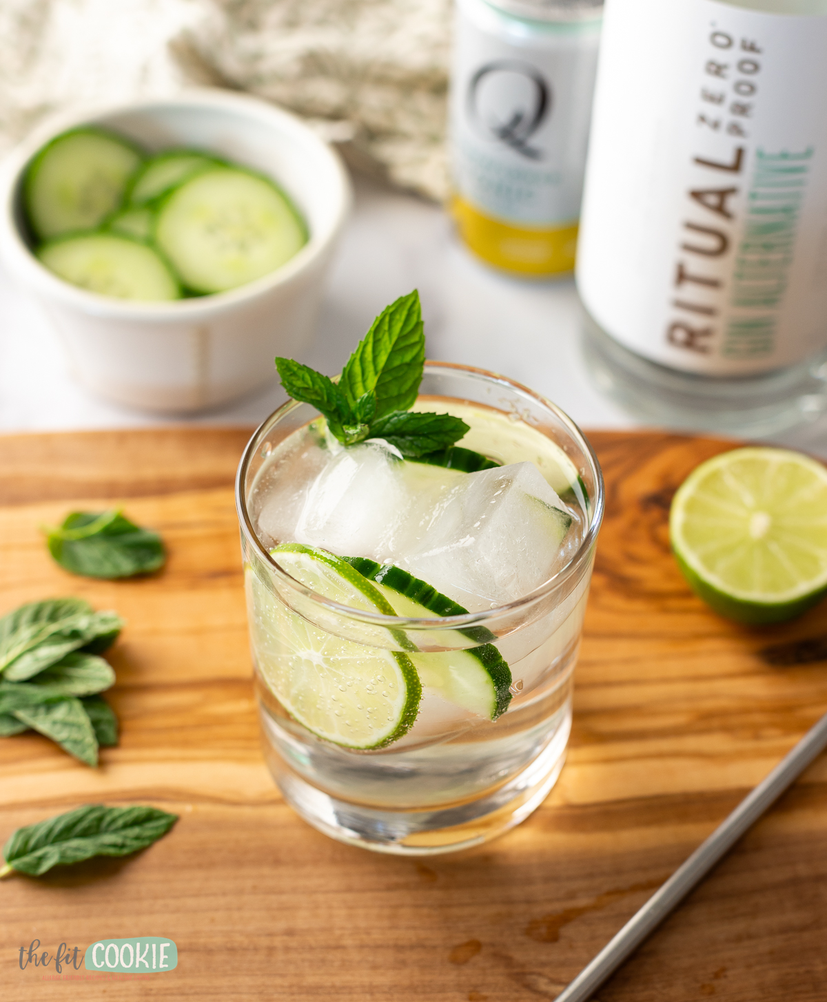 A glass filled with virgin gin and tonic garnished with mint, cucumber, and lime. 