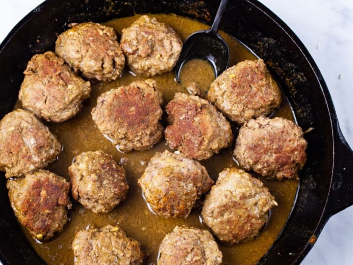 Meatballs in a skillet with sauce.
