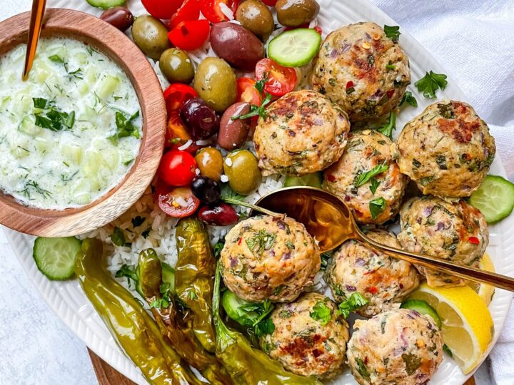 Gyro meatballs with tzatziki sauce on a plate.