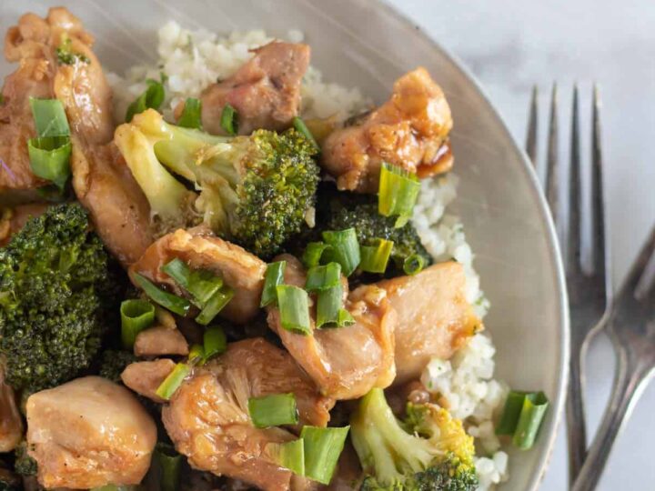 Chicken and broccoli stir fry with rice and forks.