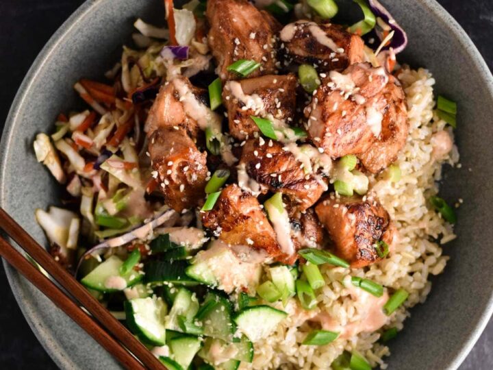 A bowl of asian chicken fried rice with chopsticks.