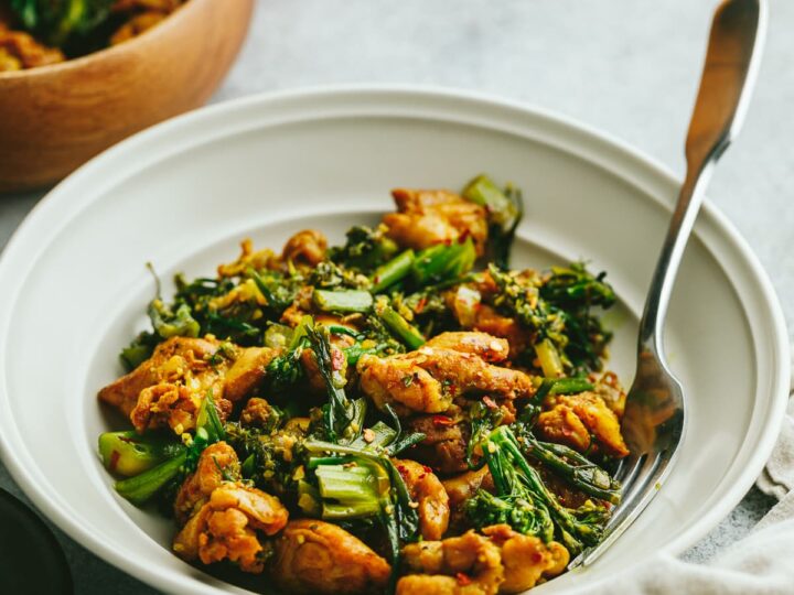 A white plate with chicken and broccoli in it.