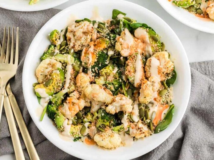 A bowl of brussels sprouts and broccoli with a fork.