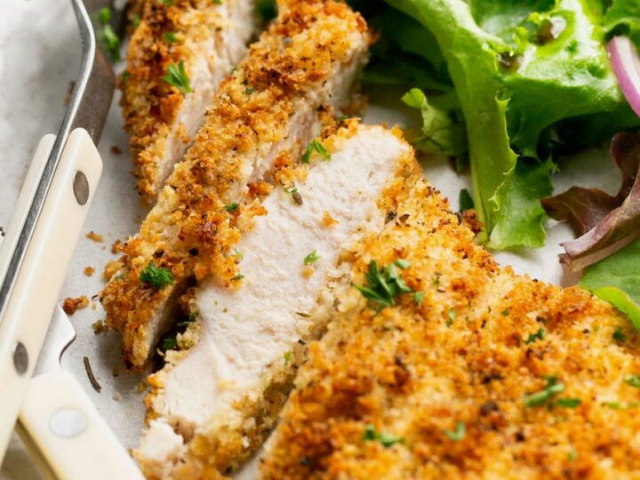 A plate with chicken and salad on it.