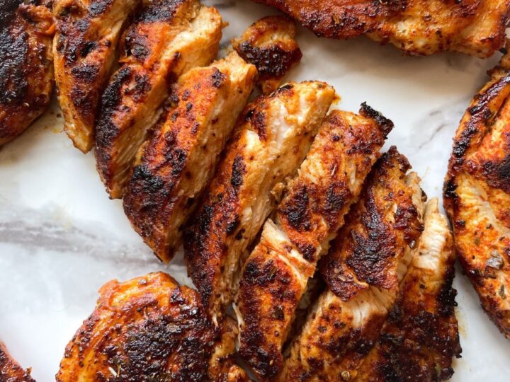 Grilled chicken breasts on a white plate.