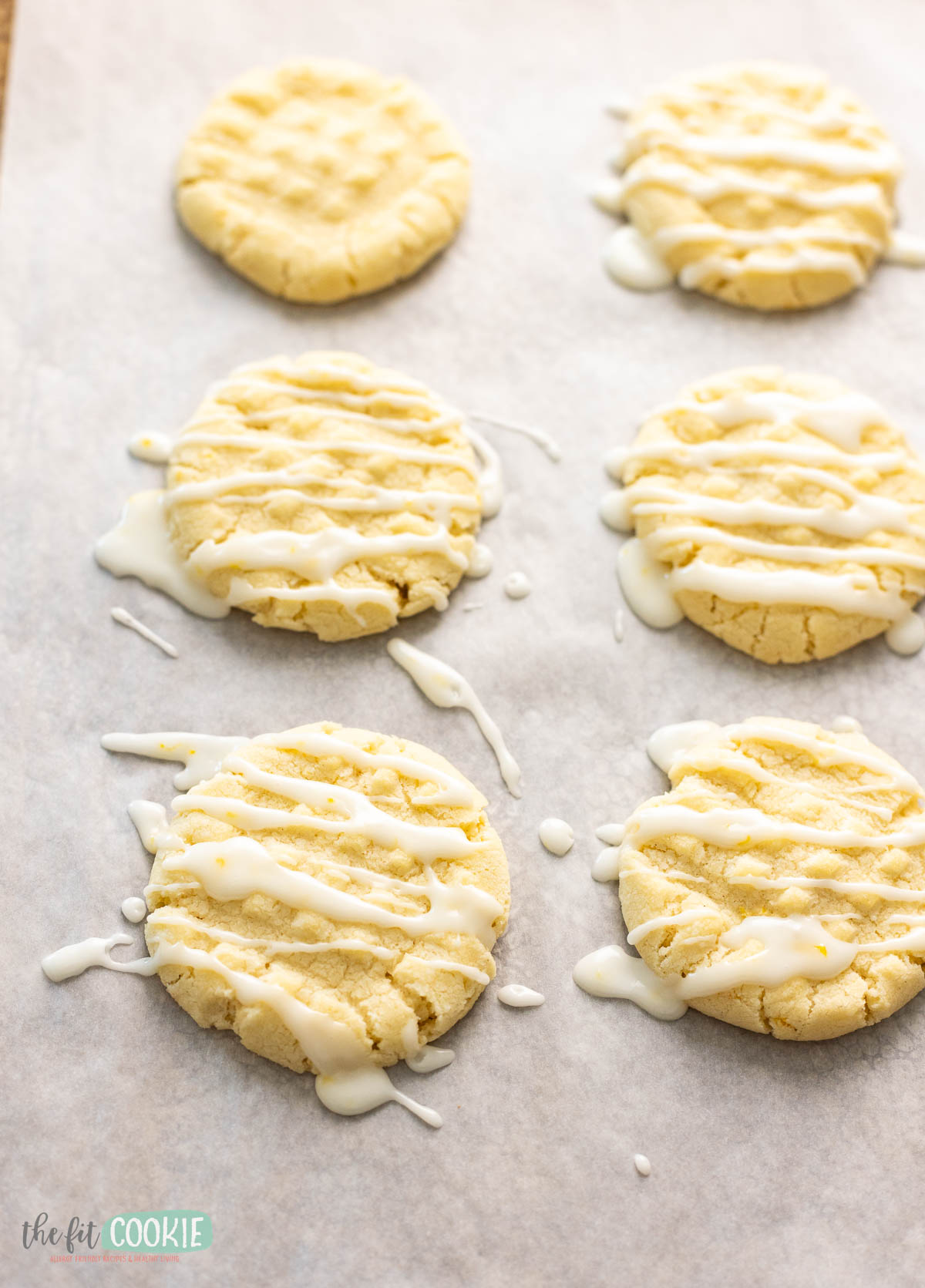 A group of gluten free lemon shortbread cookies with lemon glaze drizzled on top. 