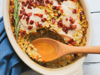 A casserole dish filled with chicken, bacon, and sage.