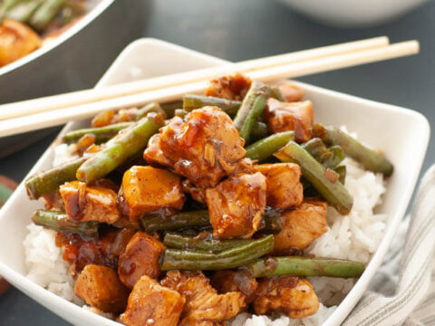 A bowl of food with chopsticks.
