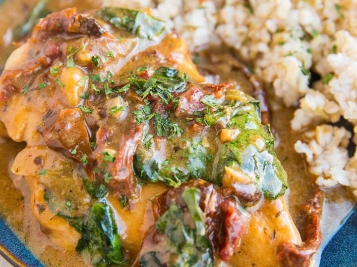 A plate with chicken, rice and spinach on it.