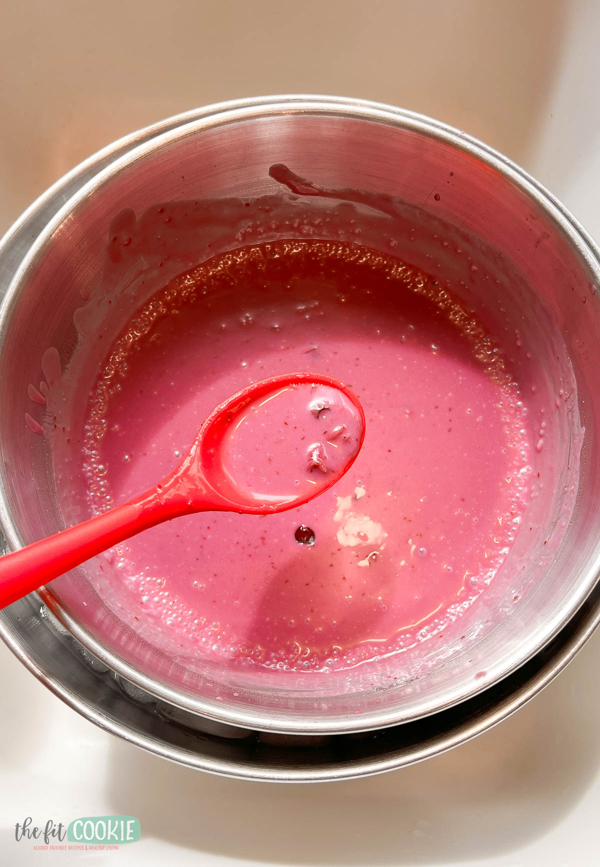 demonstrating an ice bath for ice cream mix in a metal bowl.