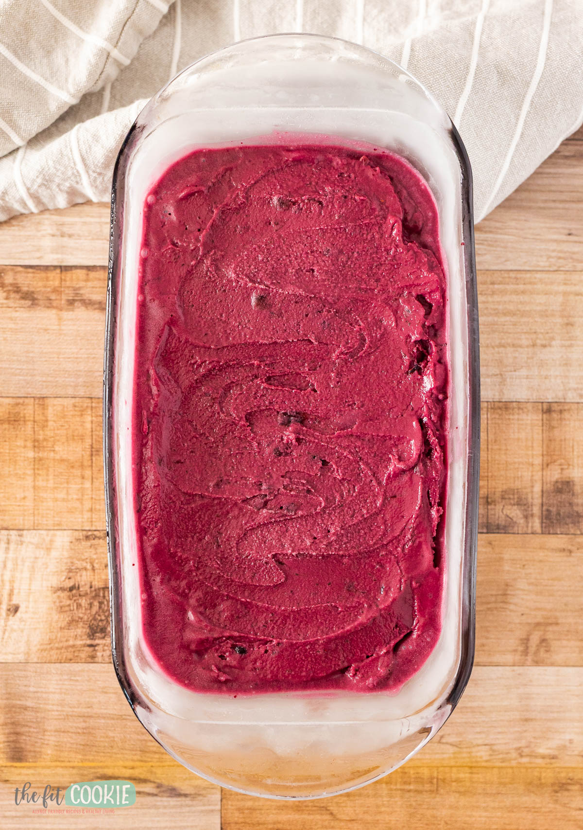 A glass loaf pan filled with dairy free huckleberry ice cream.