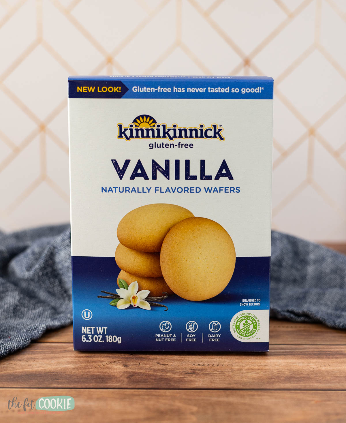 A box of Kinnikinnick gluten-free vanilla wafers sits on a wooden surface with a blue cloth in the background, perfect for making dairy free tiramisu.