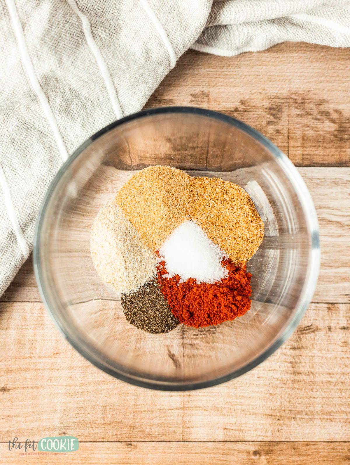 small glass bowl containing spices before mixing. 