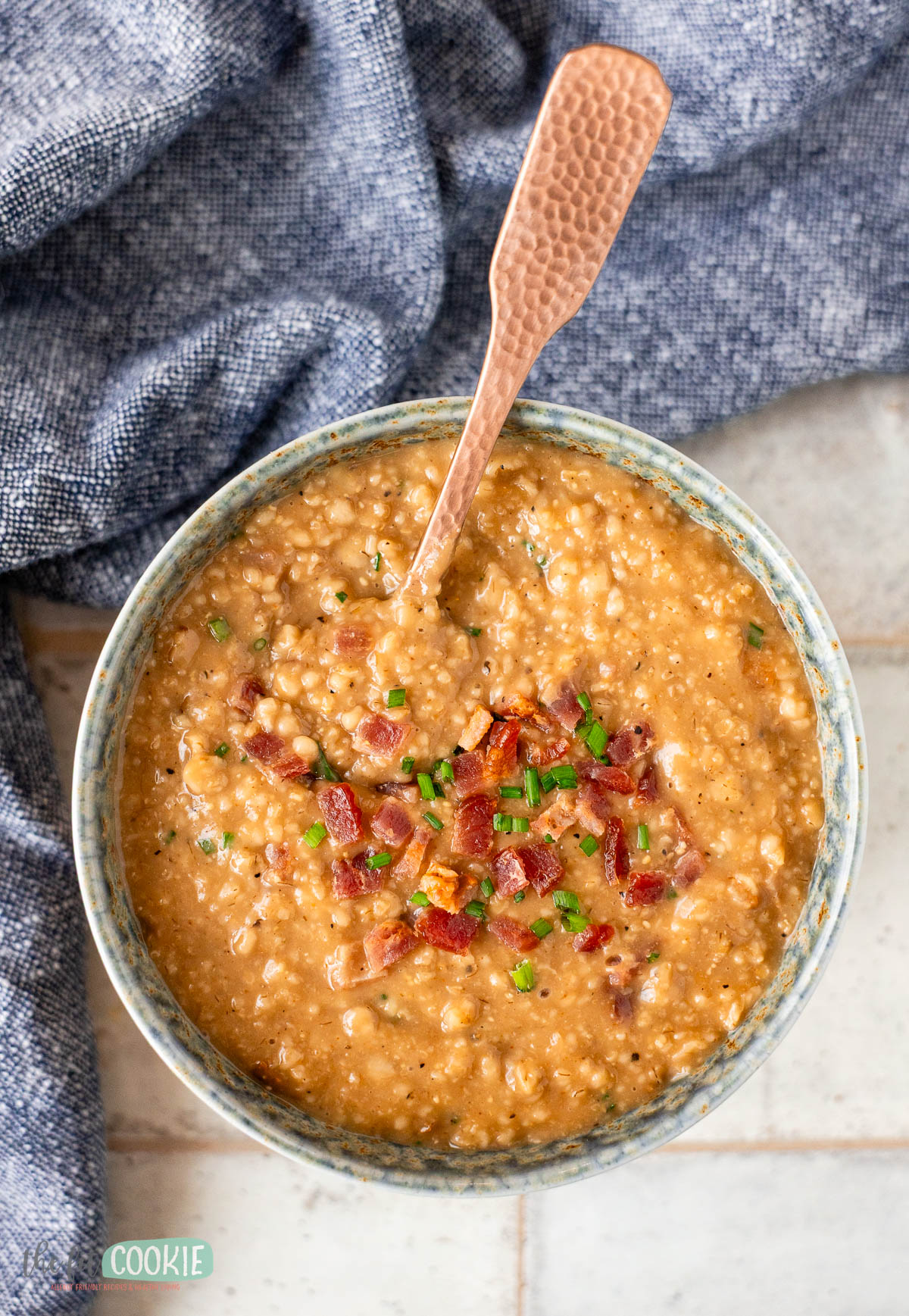 overhead photo of savory oatmeal in a bowl with bacon crumbled on top.